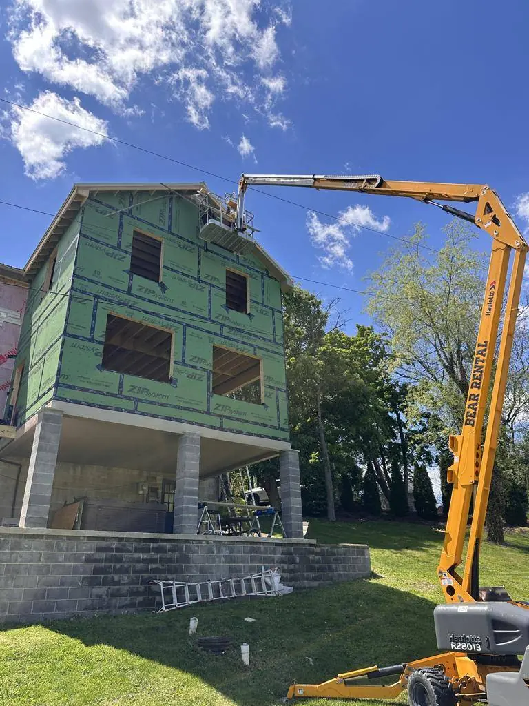 Boom lift brought in to install soffit and fascia more than four stories above the low side of the site