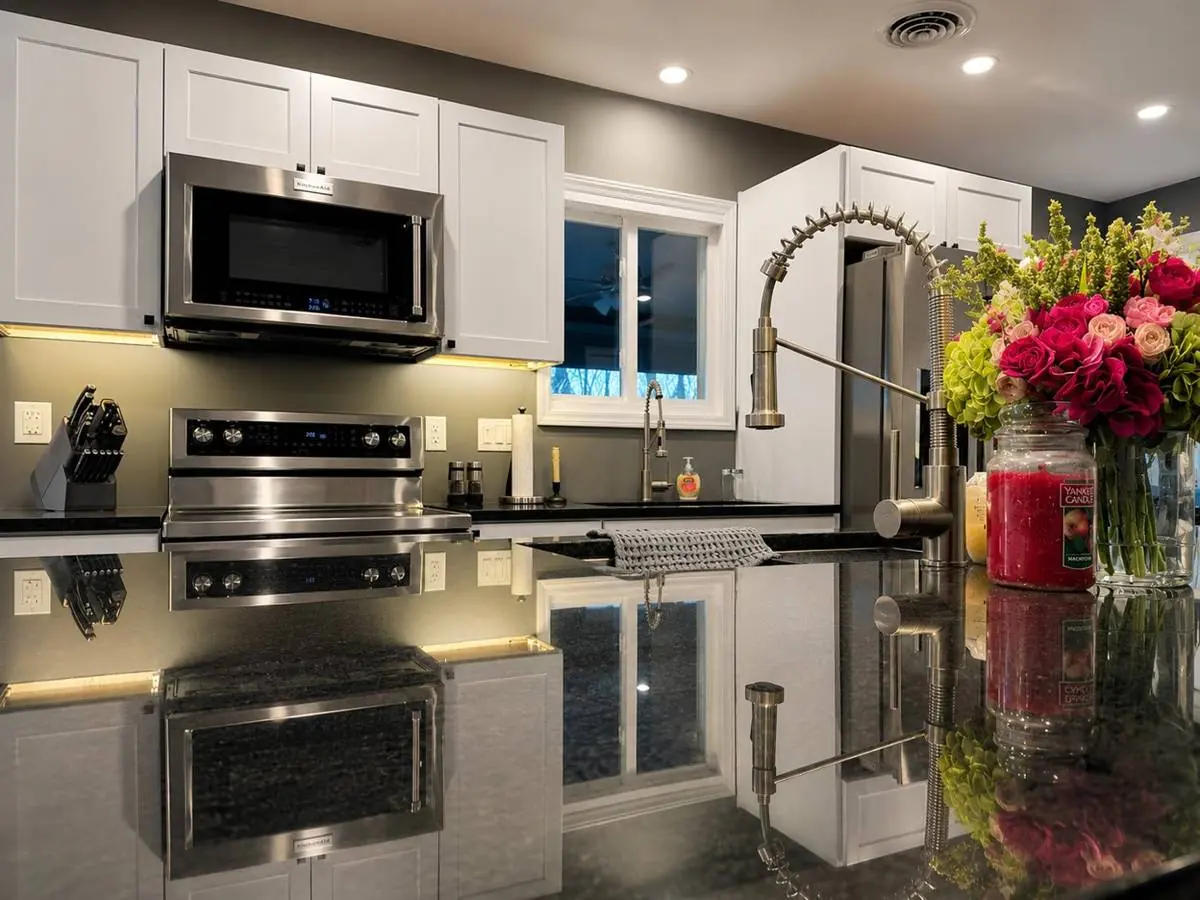 Kitchen detail showing the range, pull-down faucet and polished granite countertop