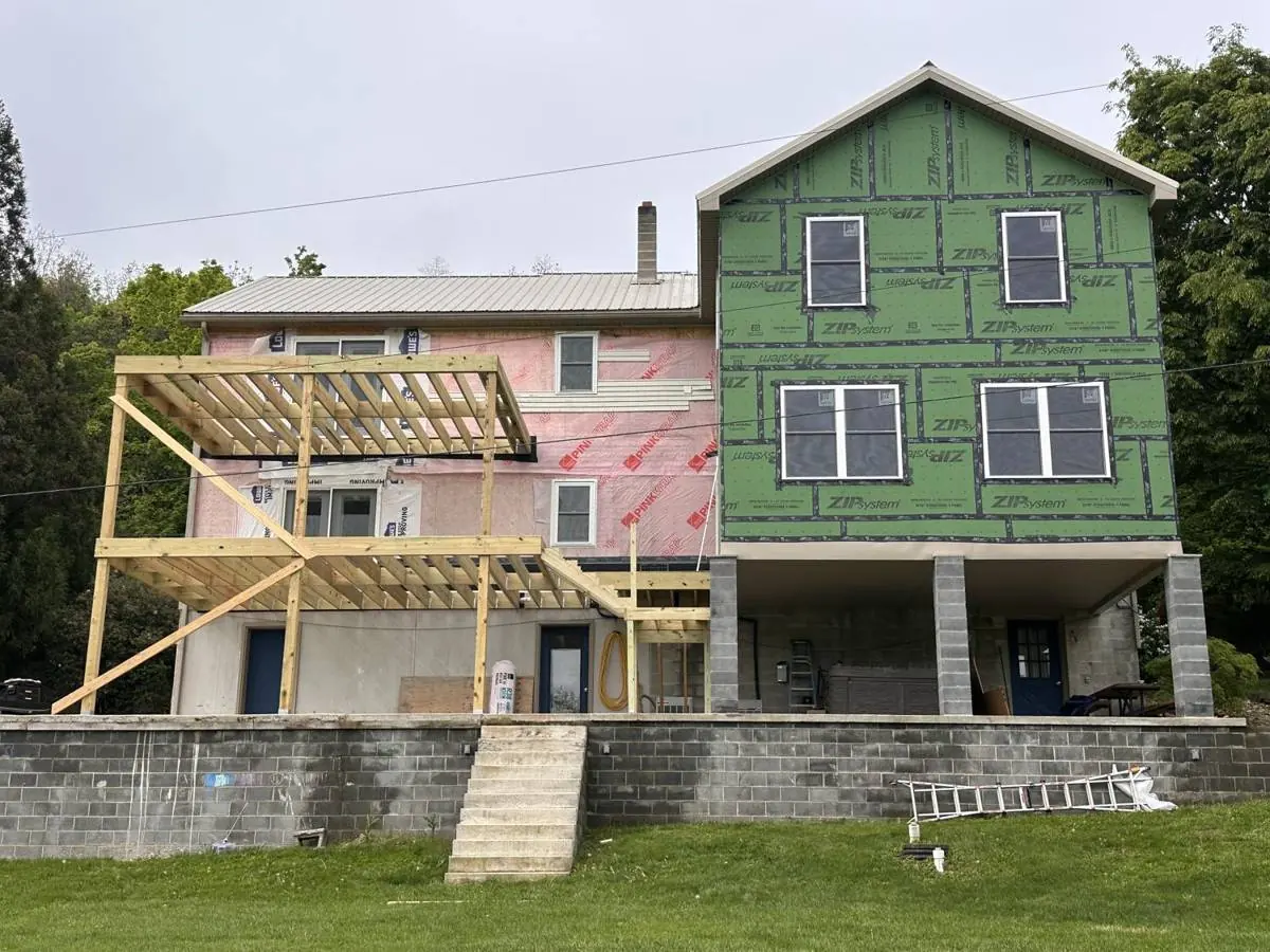 Wide view of the finished structure showing how the new roofline meets the existing house