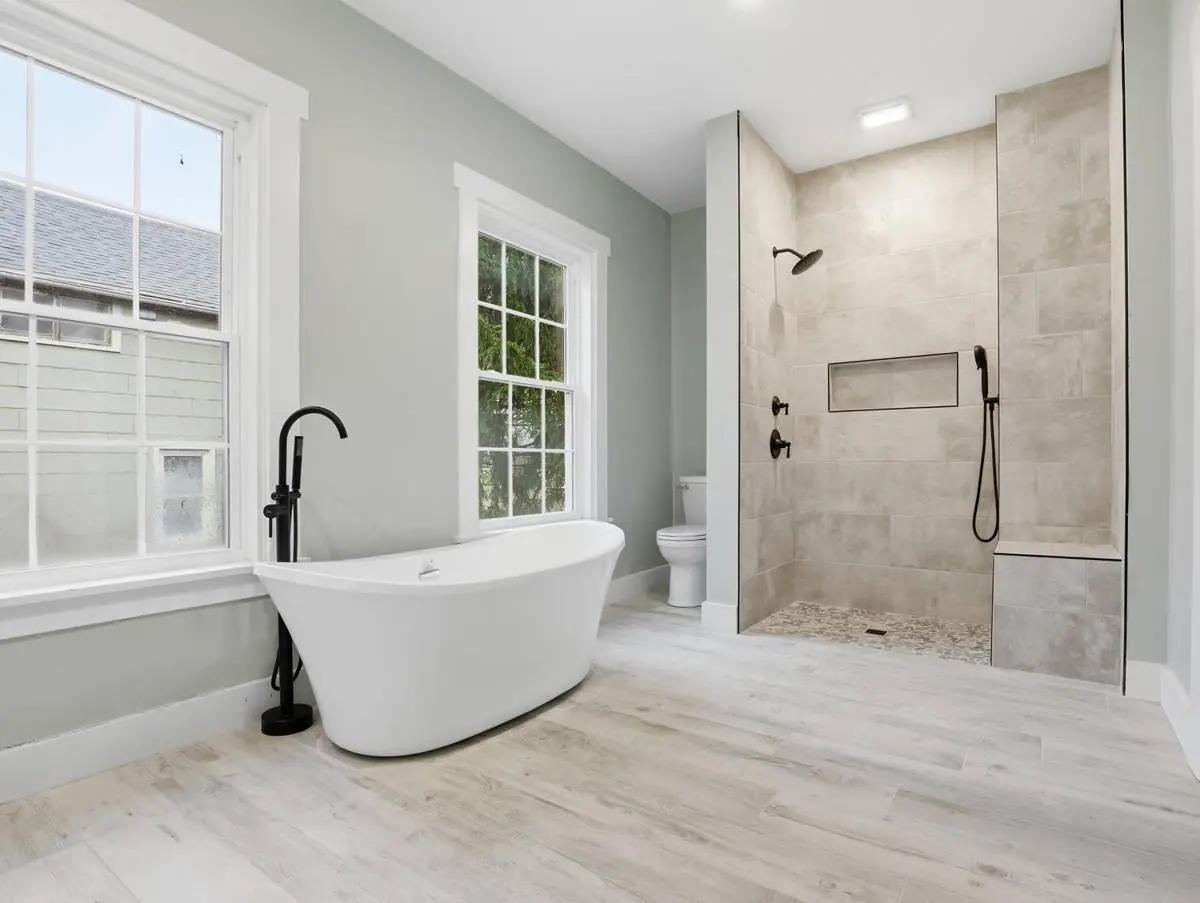 Master bathroom with a freestanding tub and a curbless tiled shower, with the tile floor running flat into the shower