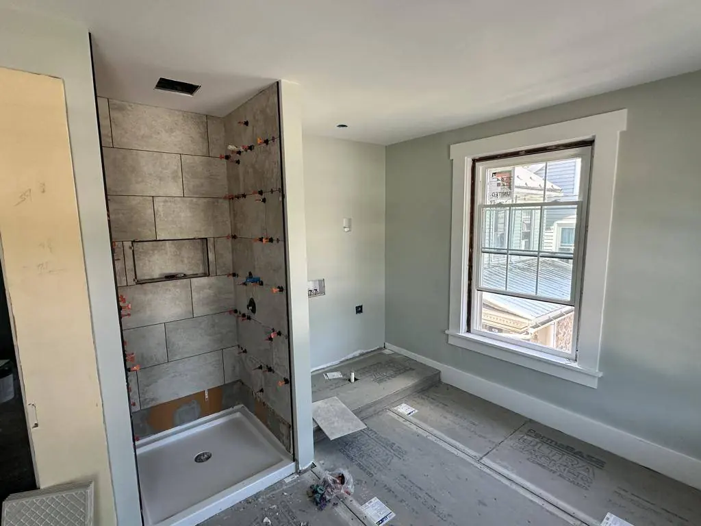 Second-floor bathroom under construction, with the shower walls being tiled