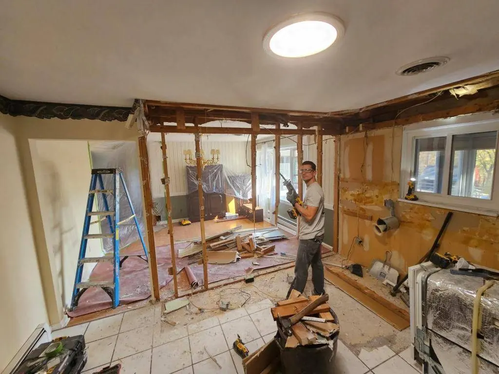 Wall opened between the kitchen and living room with temporary support in place during demolition
