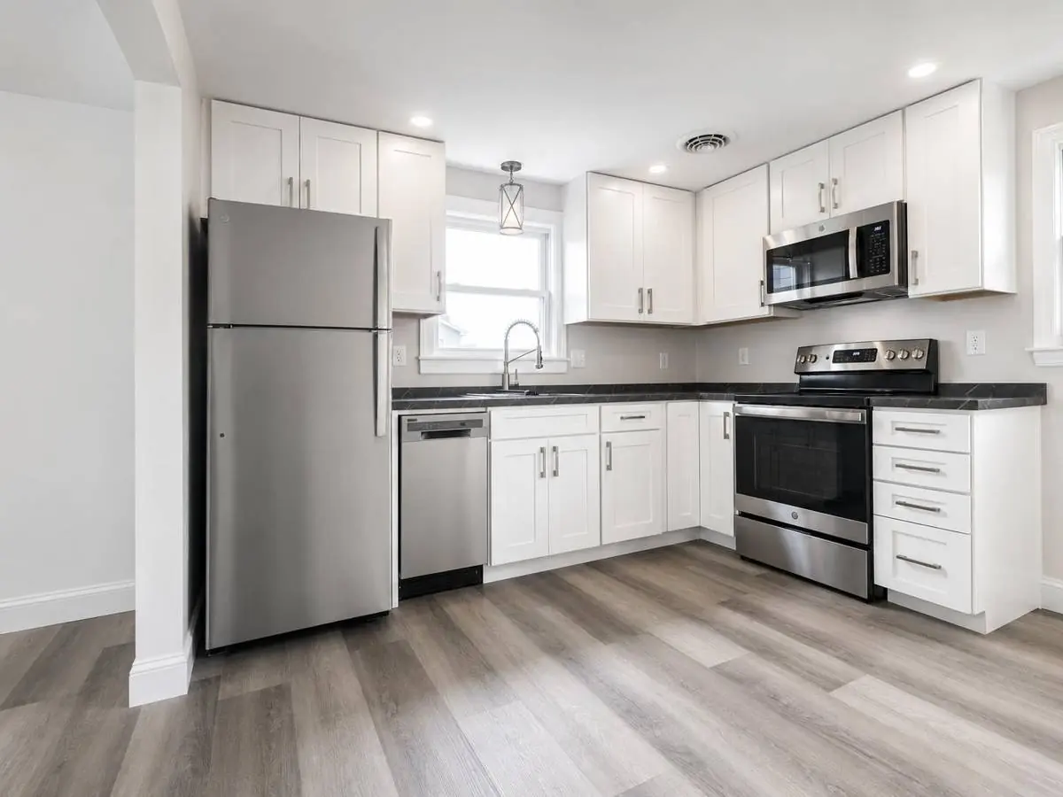Finished kitchen remodel in Selinsgrove, Pennsylvania, with white shaker cabinets, dark countertops, stainless appliances and luxury vinyl plank flooring
