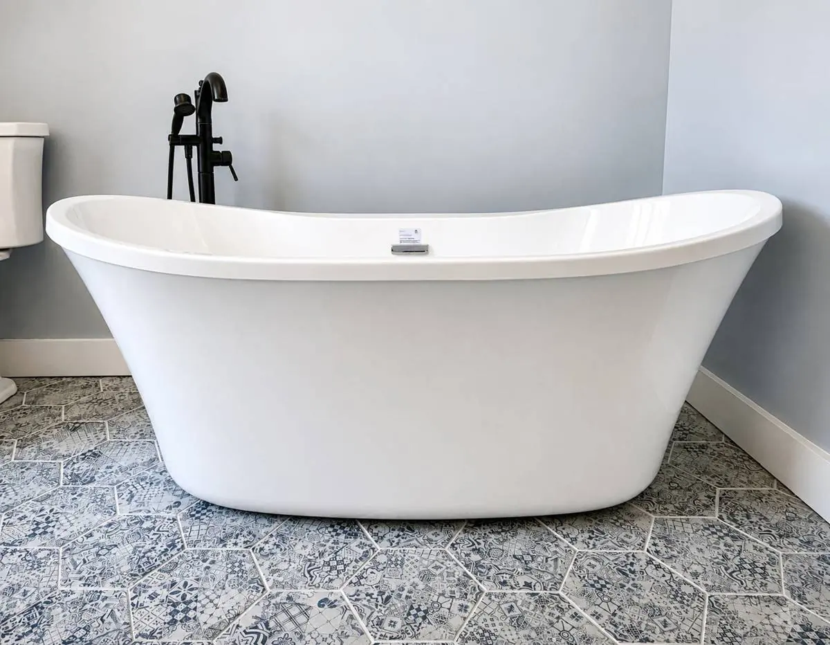Freestanding soaking tub against the patterned blue and white hexagon tile floor