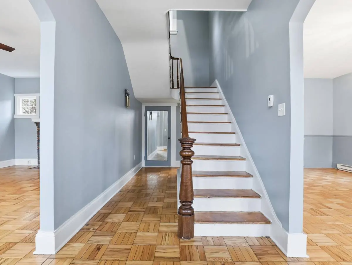 Restored entry hall of an 1844 house in Trevorton, Pennsylvania, with the original staircase, turned newel post and parquet flooring preserved