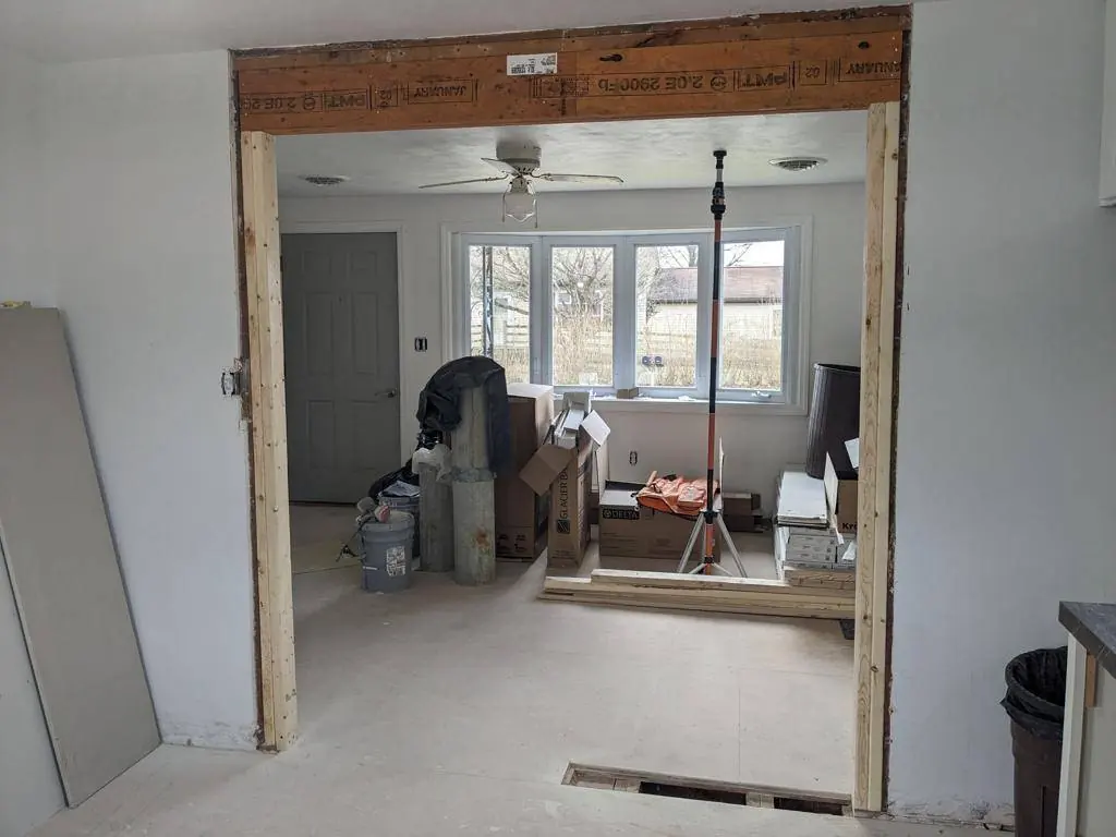 New structural header installed across the opening between the kitchen and living room to carry the load the wall was carrying