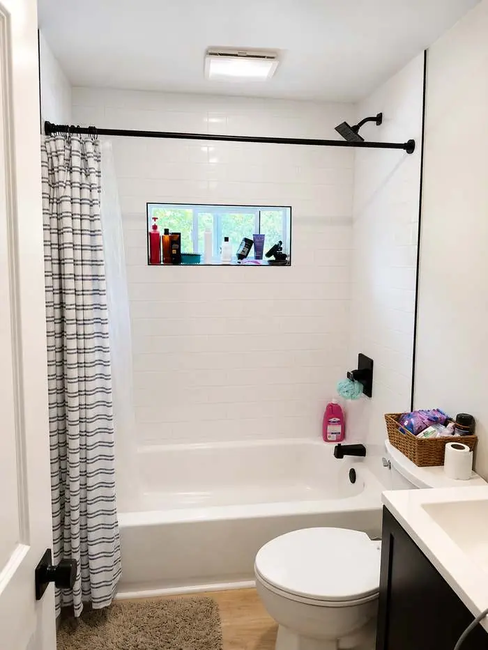 Finished bathroom with a white subway tile tub surround