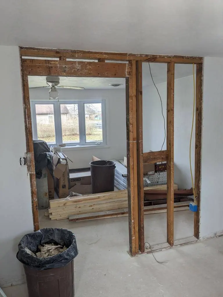 Wall between the kitchen and living room opened up, showing the original framing removed