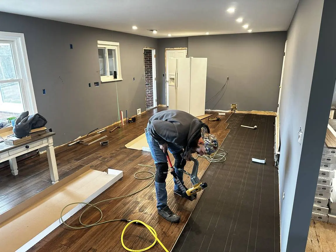 Installing solid hardwood flooring in place of the originally specified luxury vinyl plank, added by written change order