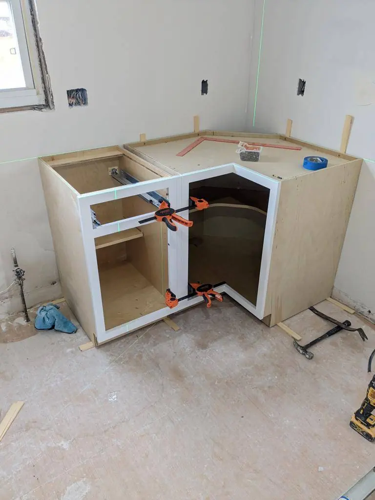 Base cabinets set and clamped together, including the blind corner cabinet, before countertops