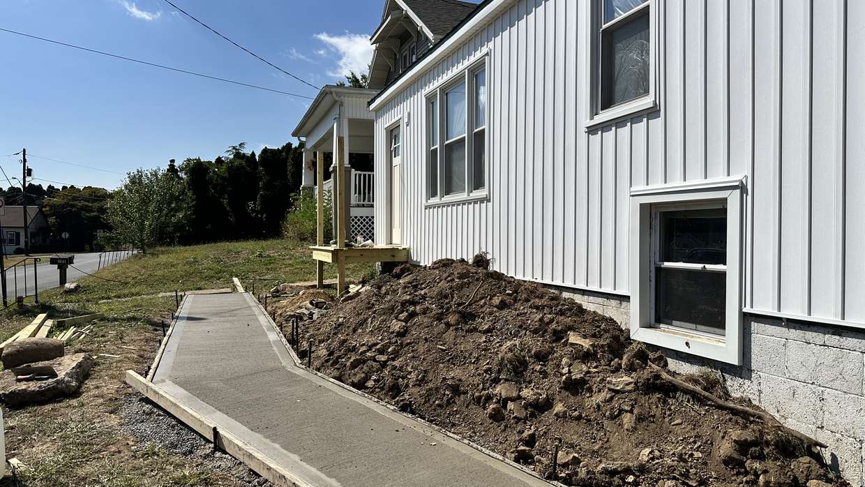Regraded and seeded yard with a new concrete walk after an established bamboo stand was excavated