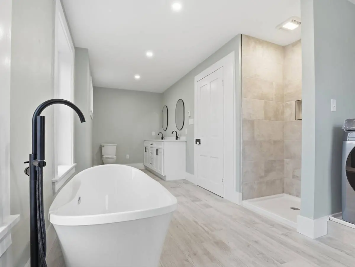 Second bathroom with a freestanding tub, double vanity, walk-in tiled shower and laundry